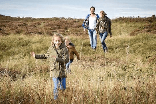 Gezin wandelt door de duinen